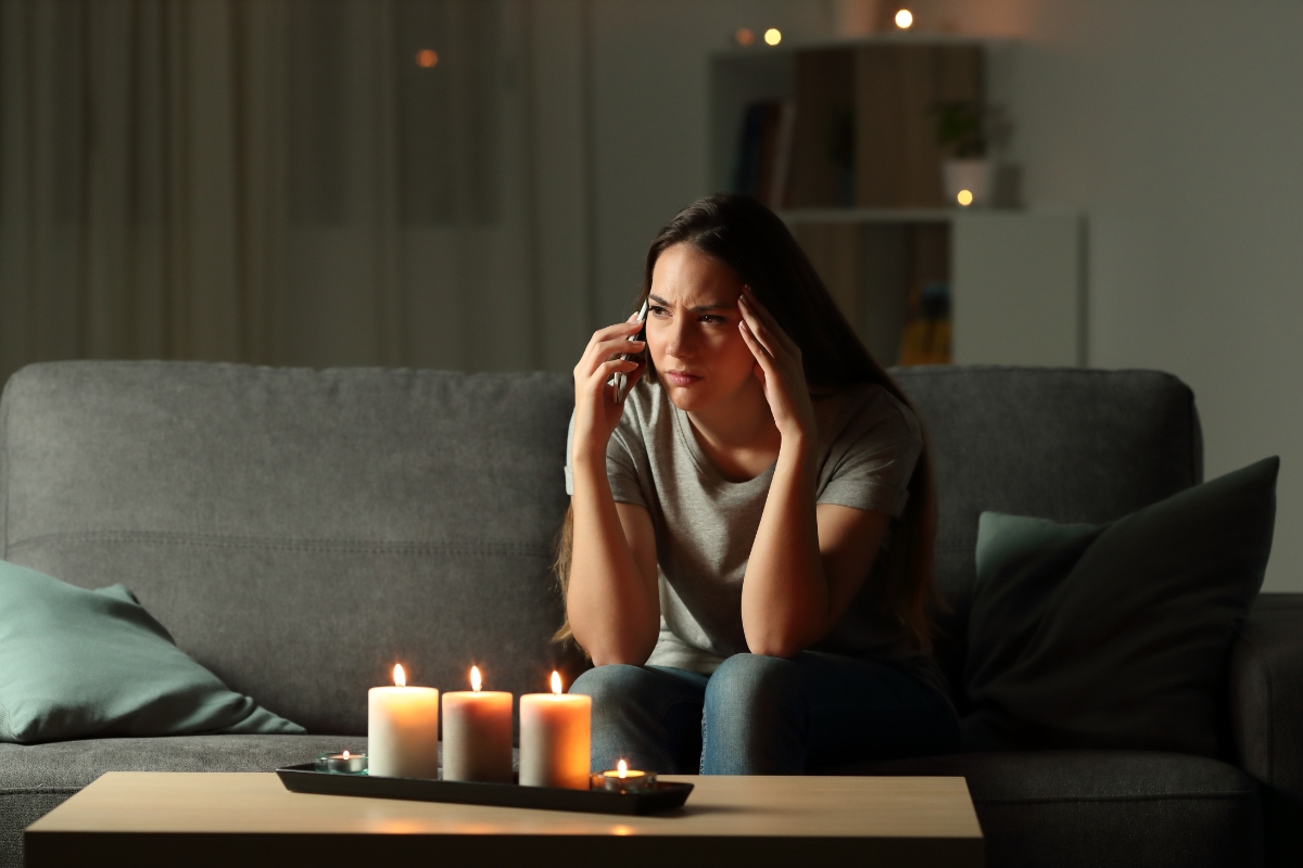 Romance scams worried person on the phone with candles