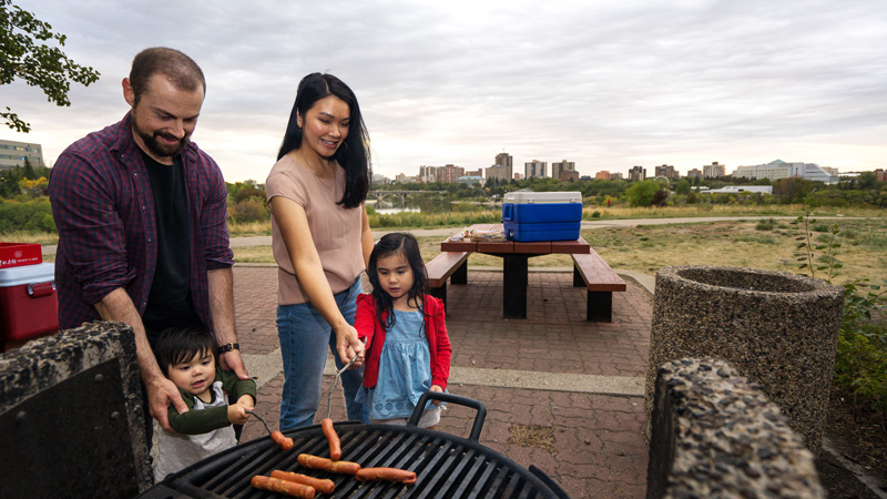 a family roasting hot dogs at a park