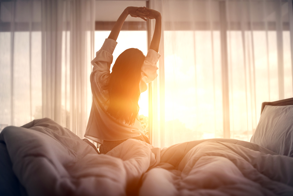 Woman stretching as she wakes up early